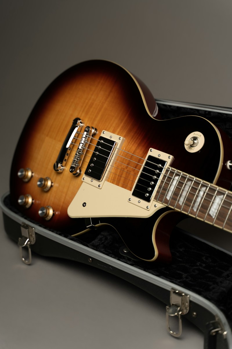 Sunburst electric guitar resting in an open case.