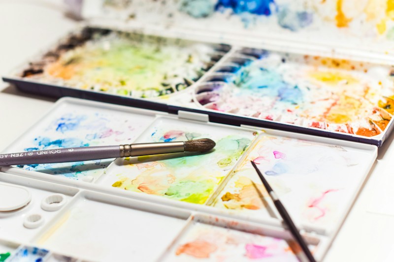 Watercolour palette and brushes with mixed pigments.